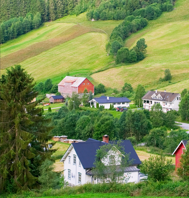 Country setting with some houses and rolling landscape of small farms and woods.